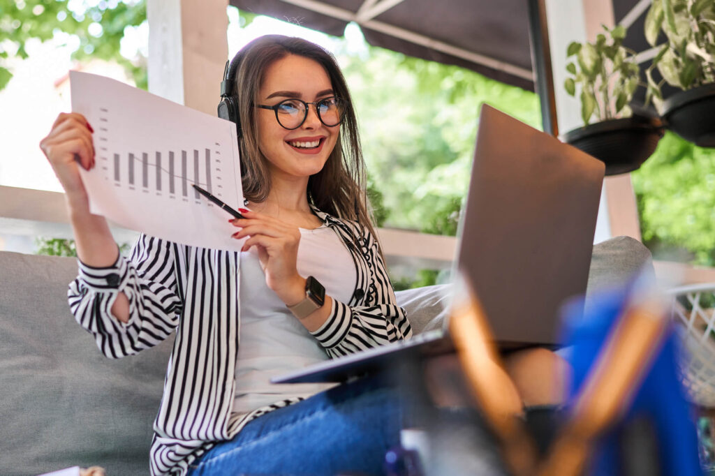 Mulher trabalhando em um laptop ao ar livre, representando o conceito de orçamento e criação de sites.